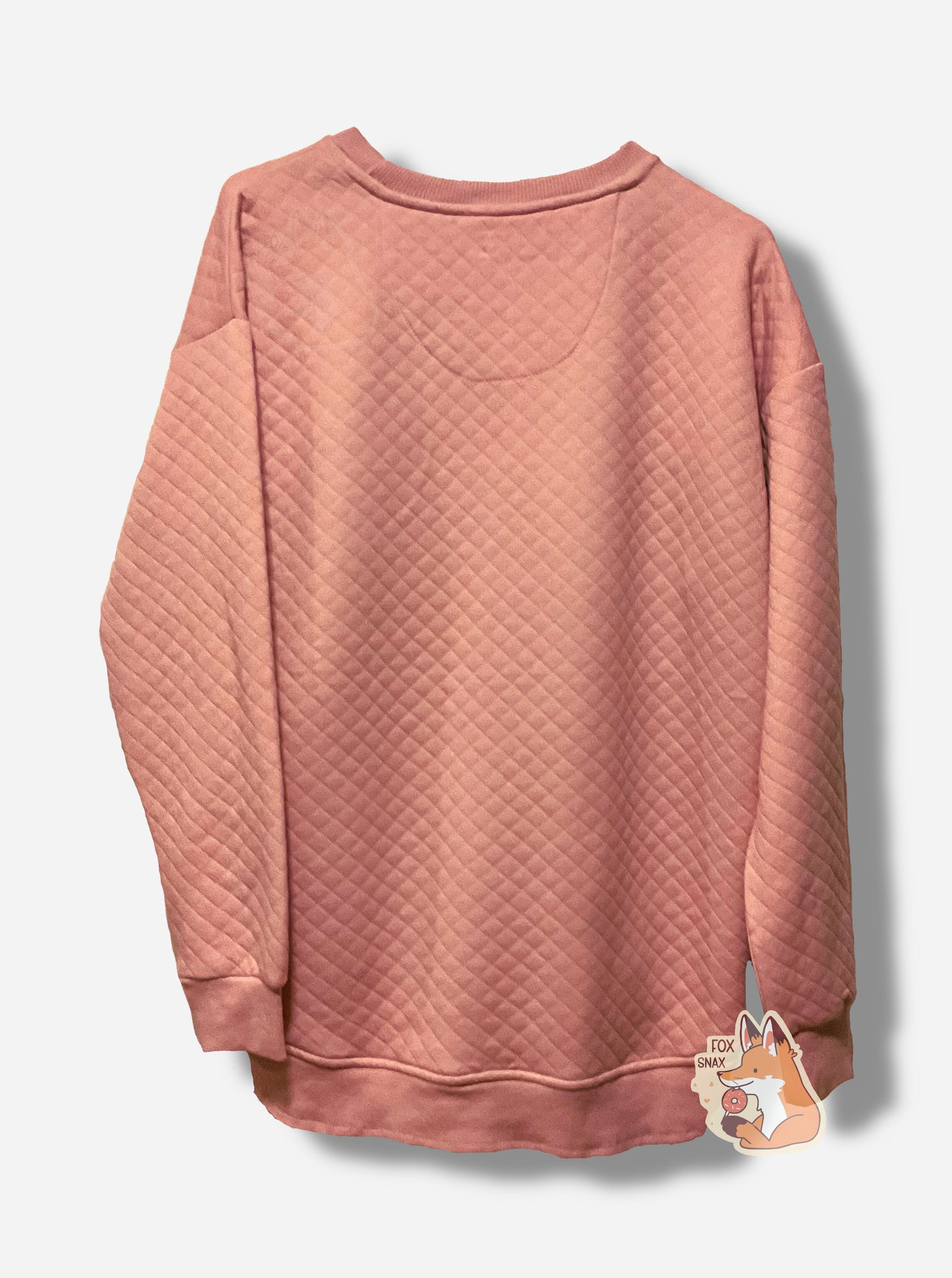 A picture of the back of a light pink, quilted pattern fleece sweater/sweatshirt.  