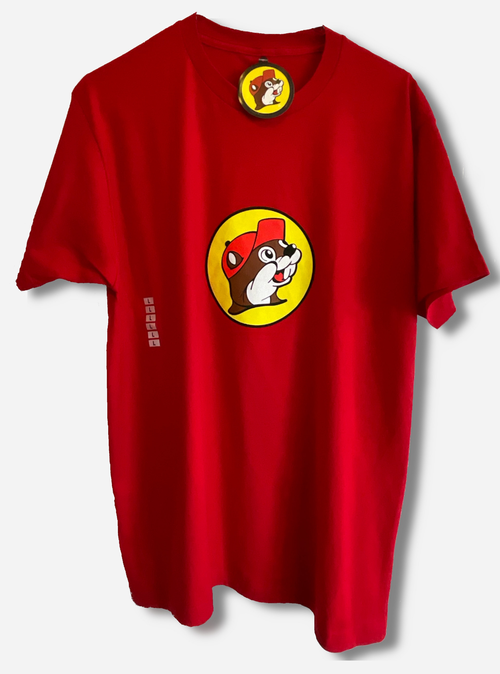 A picture of a red t-shirt, sporting the Buc-ee the Beaver logo - a jolly brown and white furred beaver, wearing a red ballcap, against a yellow circular backdrop.