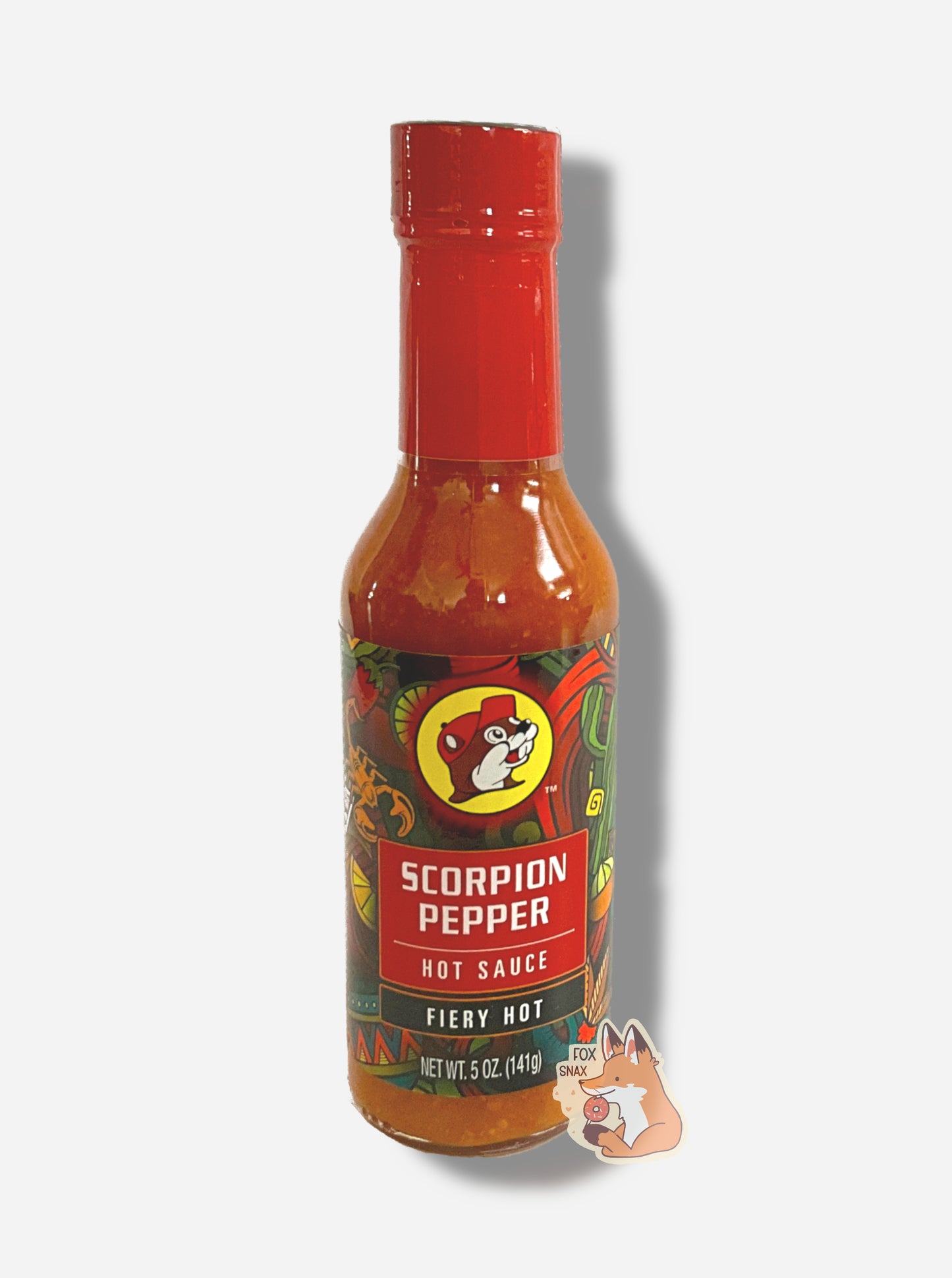 A picture of a small, tall glass bottle of hot sauce.  The top of the bottle is sealed with a plastic top.  The front label of the bottle reads SCORPION PEPPER HOT SAUCE, HOT.  The Buc-ee's logo can be seen on the front; the background is a fairly busy abstract artwork featuring a scorpion, a lemon, a taco, and a maracas.  The sauce inside is an orange/red.