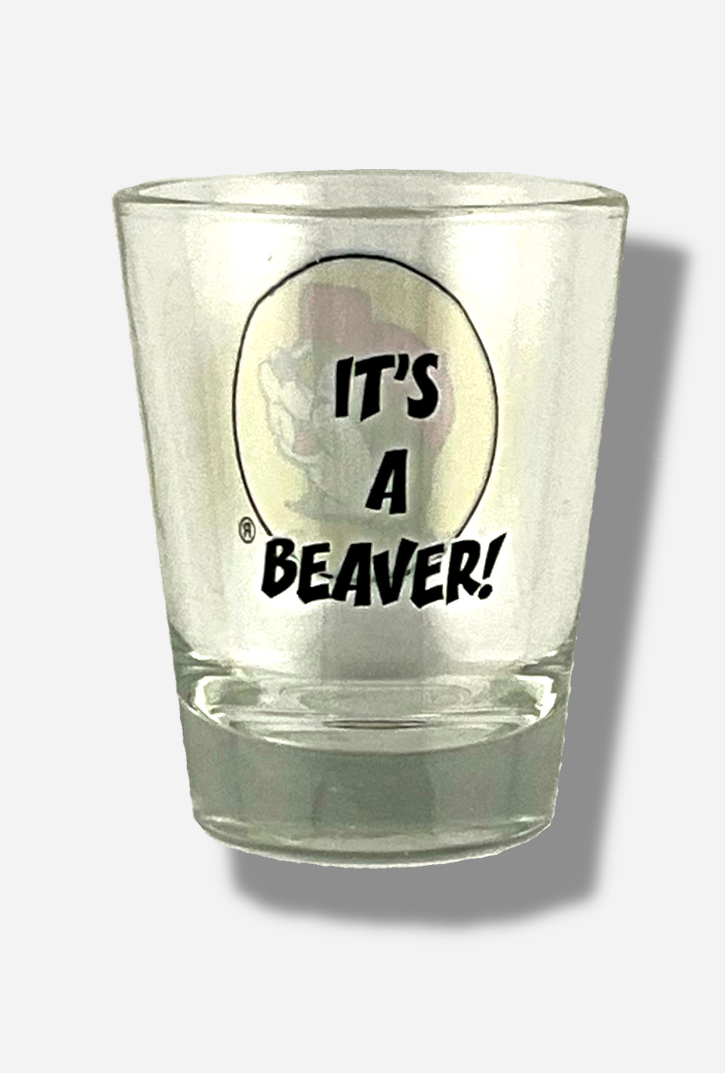 A picture of the back of glass shot glass.  The glass is clear.  In the middle of the back are the words, in black front, IT'S A BEAVER!