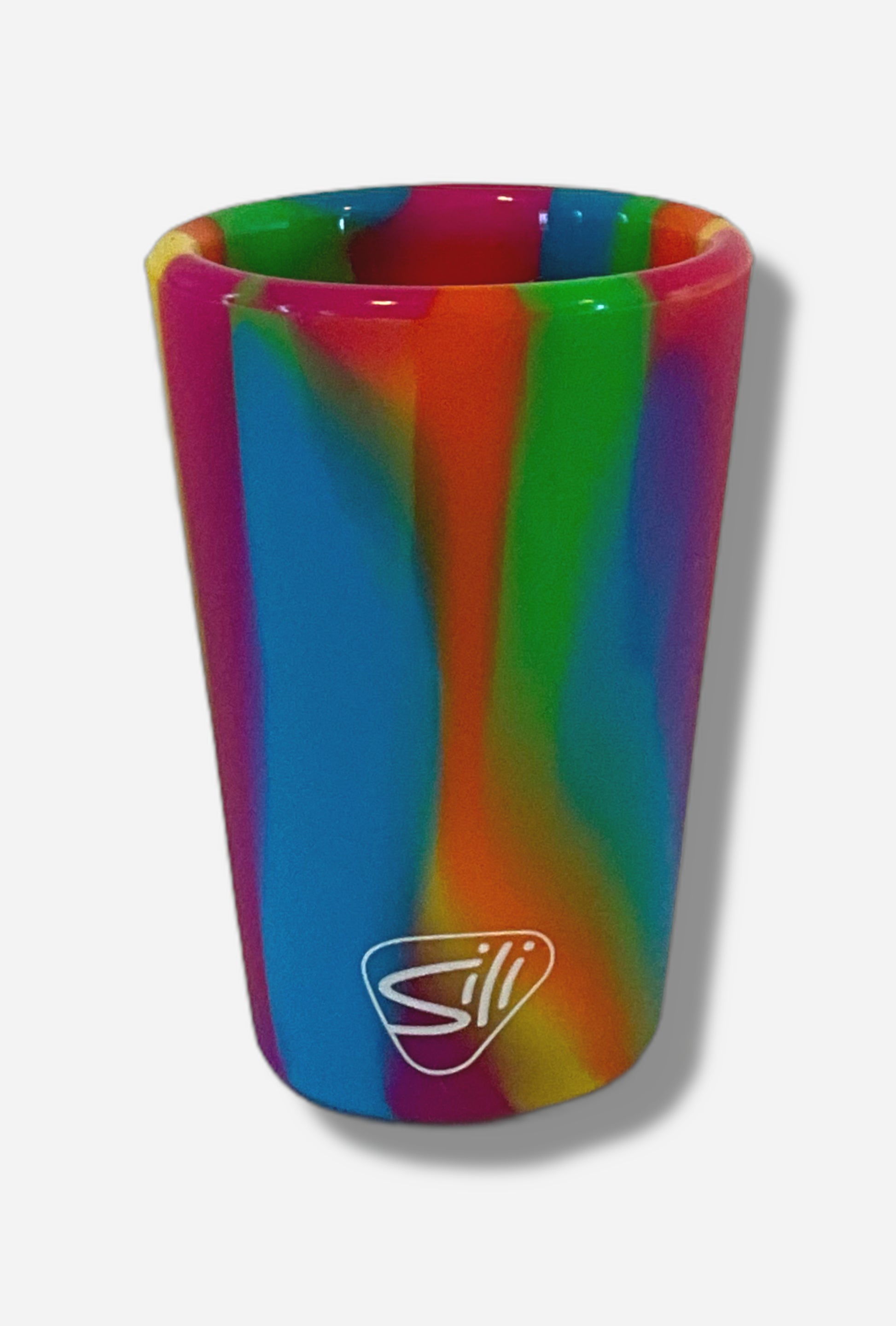 A picture of the back of a silicone shot glass.  The material is streaky rainbow colors.  A small 'sili' logo in white is seen on the bottom; the manufacturer of the shot glasses.  