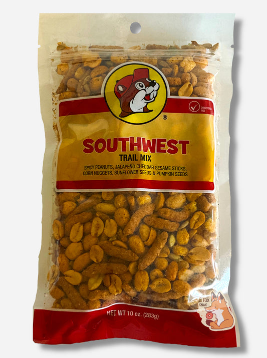 A picture of a bag of Buc-ee's Southwest trail mix.  The bag is clear plastic, and says SOUTHWEST TRAIL MIX on the front, with the iconic beaver logo wearing a red ball cap.  At the bottom, after the product listing, peanuts, sesame sticks, corn nuggets, sunflower seeds, and pumpkin seeds can be seen.  There appears to be a fair amount of spices on all the products.