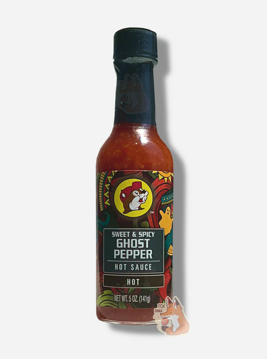 A picture of a small, tall glass bottle of hot sauce.  The top of the bottle is sealed with a plastic top.  The front label of the bottle reads SWEET & SPICY GHOST PEPPER HOT SAUCE, HOT.  The Buc-ee's logo can be seen on the front; the background is a fairly busy abstract artwork featuring an orange ghost, sun, and several colorful abstract shapes.  The sauce inside is dark red.