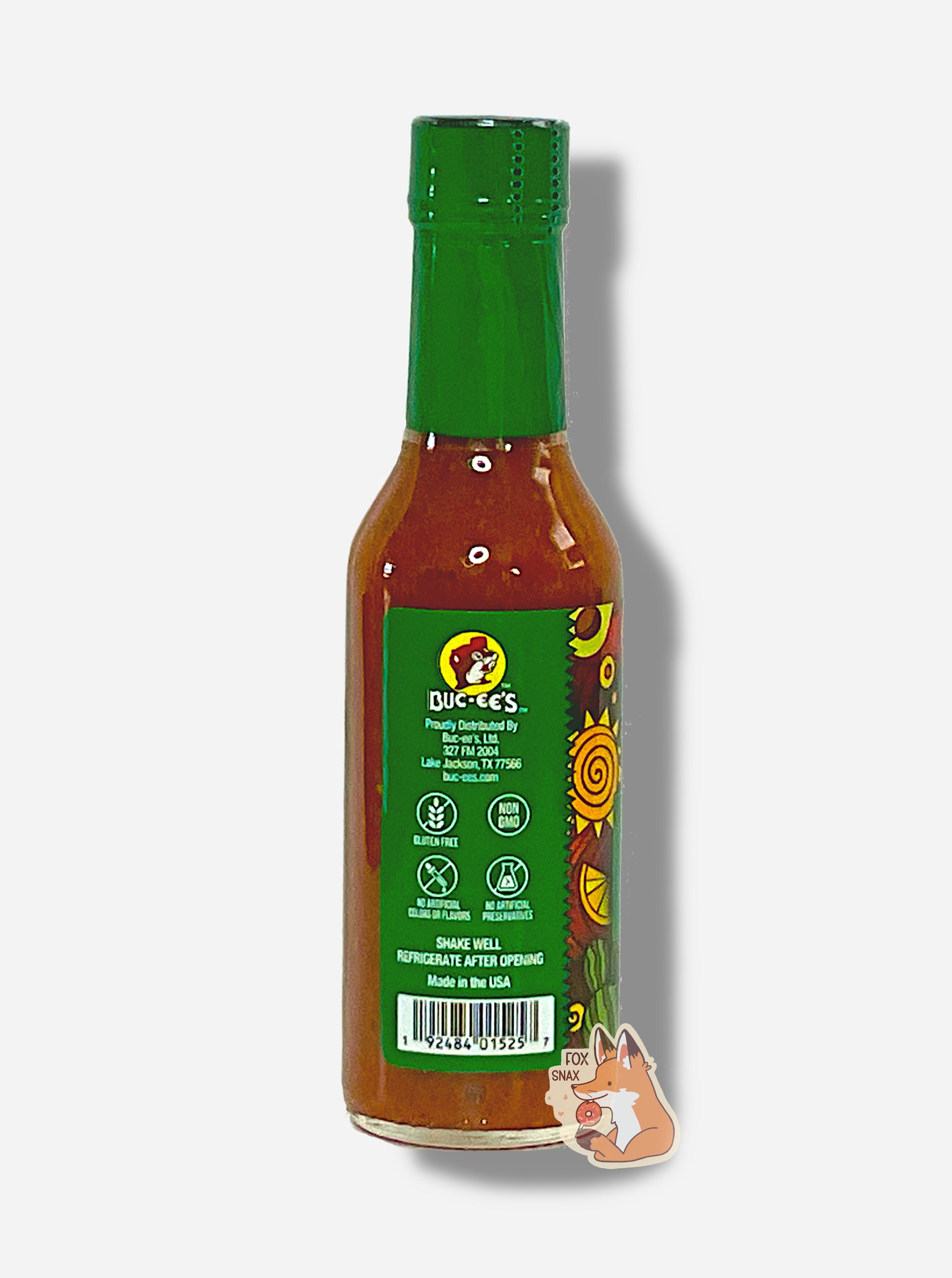 A picture of a small, tall bottle of hot sauce. The top of the bottle is sealed with a shiny green plastic top.  The back reads GLUTEN FREE, NON GMO, NO ARTIFICIAL COLORS OR FLAVORS, NO ARTIFICIAL PRESERVATIVES, then SHAKE WELL and REFRIGERATE AFTER OPENING.  Made in the USA.  The sauce inside is dark orange.