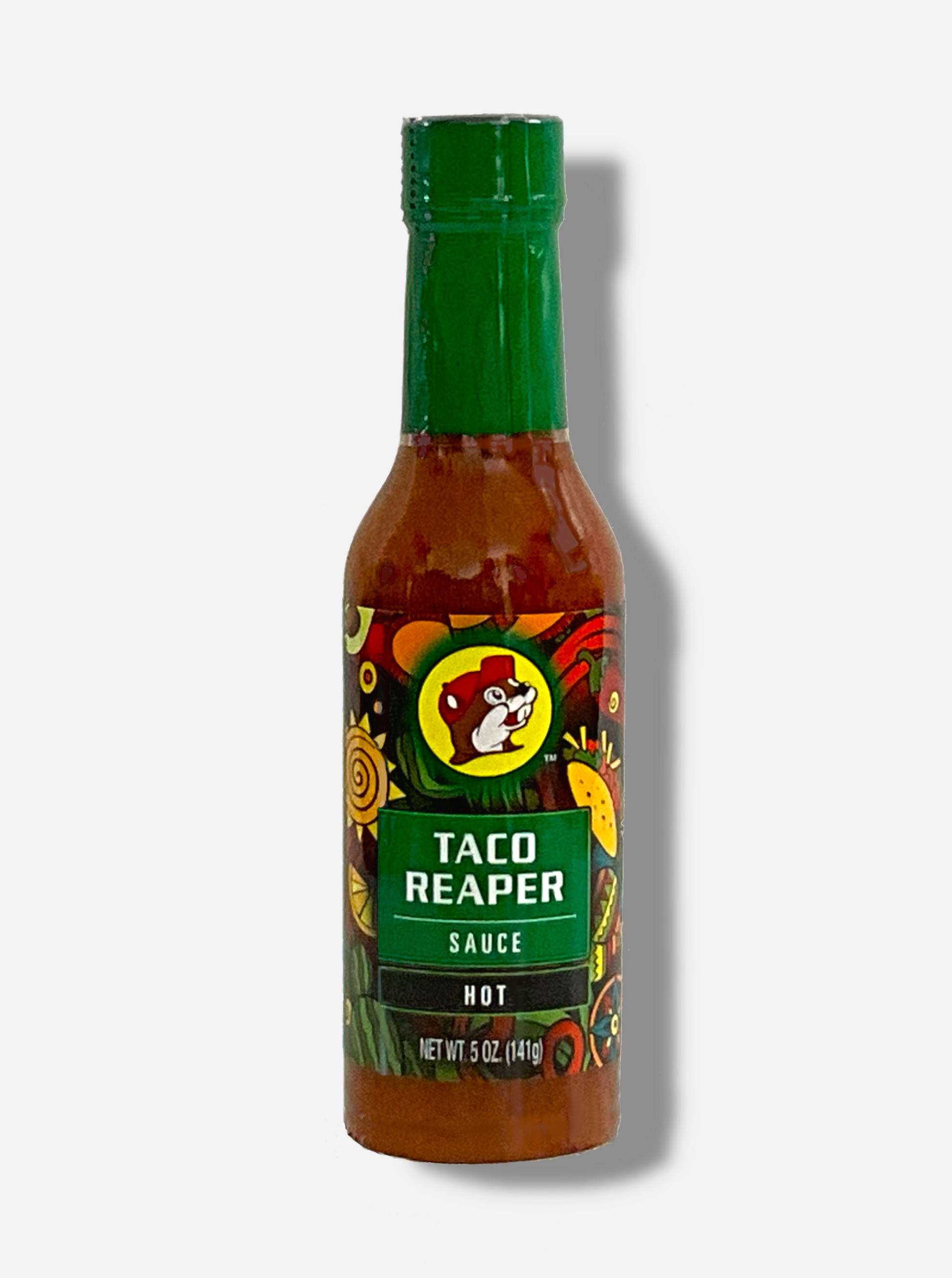 A picture of a small, tall glass bottle of hot sauce.  The top of the bottle is sealed with a shiny green plastic top.  The front label of the bottle reads TACO REAPER HOT SAUCE, HOT.  The Buc-ee's logo can be seen on the front; the background is a fairly busy abstract artwork featuring a cactus, two maracas, a lemon, a taco, and a red pepper.  The sauce inside is dark orange.