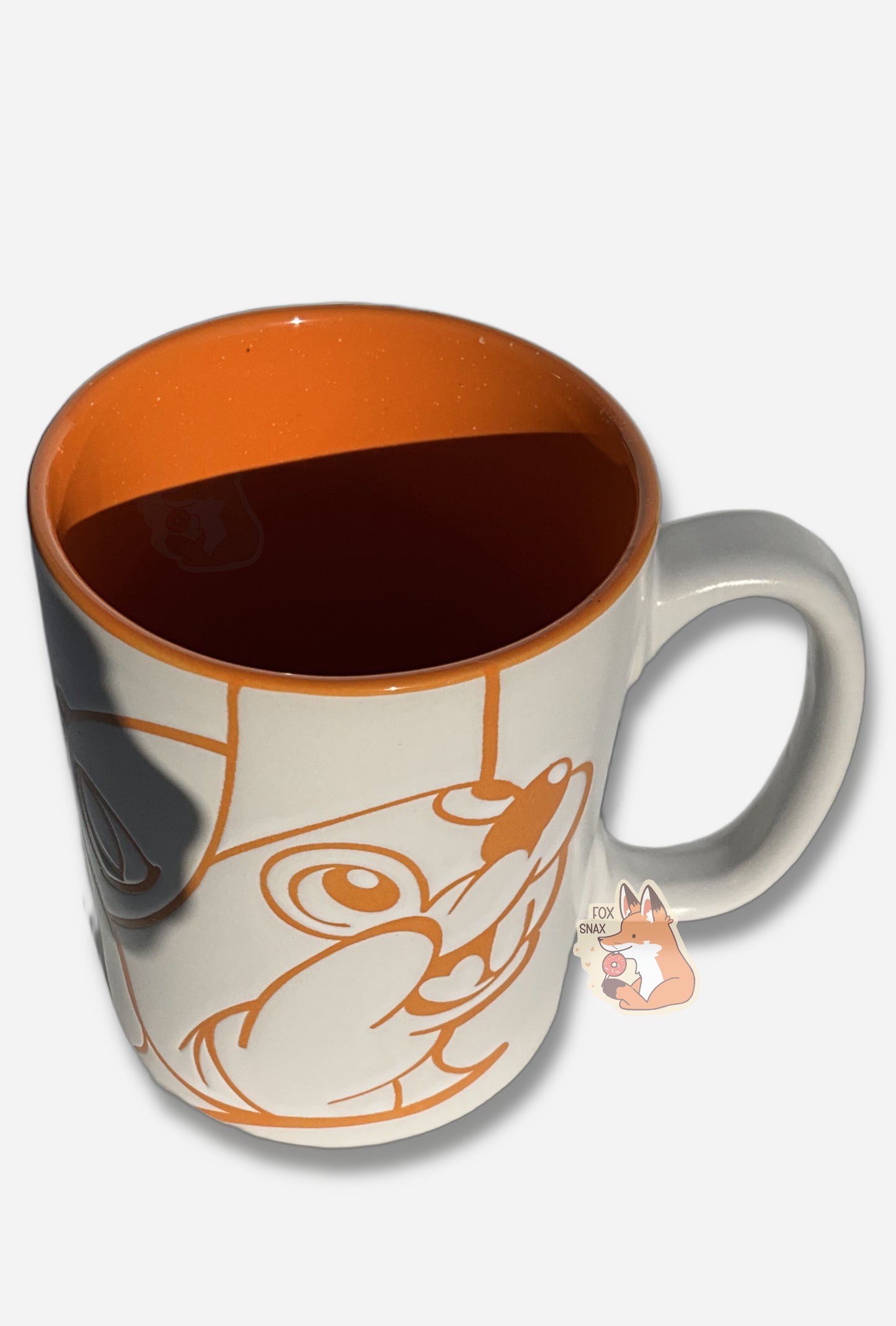 A picture of a ceramic, orange and white coffee mug.  The mug prominently features a picture of Buc-ee The Beaver on the front and back, in orange.  The interior of the mug is a bright orange as well, and rest of the mug is white.  