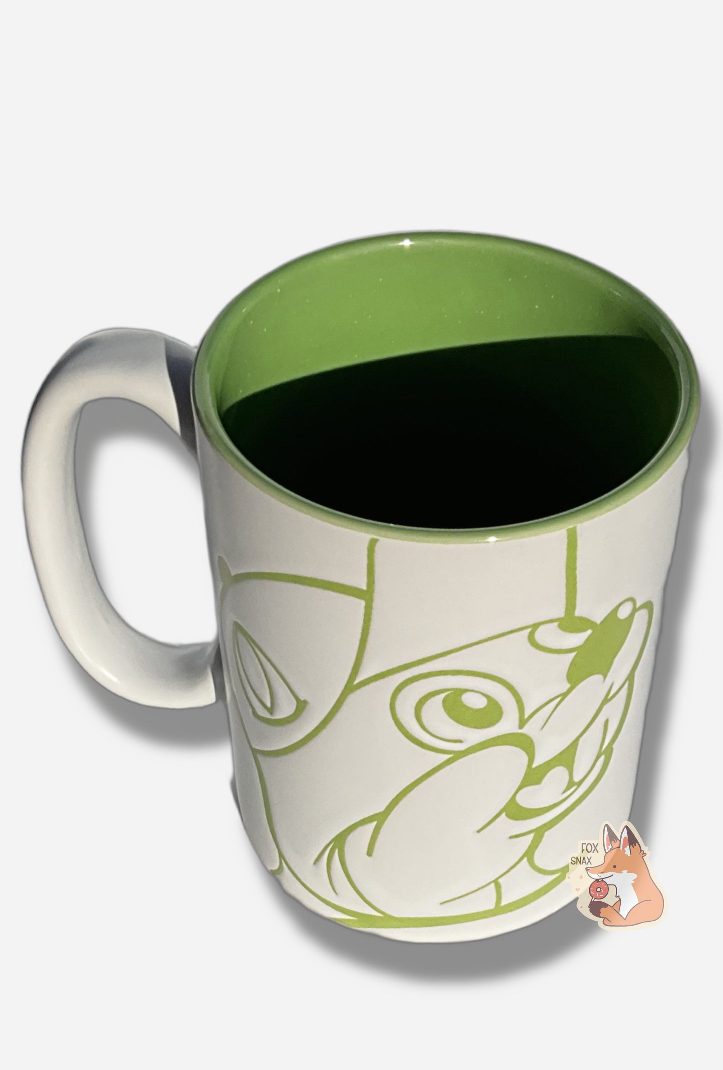 A picture of a ceramic, red and white coffee mug.  The mug prominently features a picture of Buc-ee The Beaver on the front and back, in light green.  The interior of the mug is a light green as well, and rest of the mug is white.  